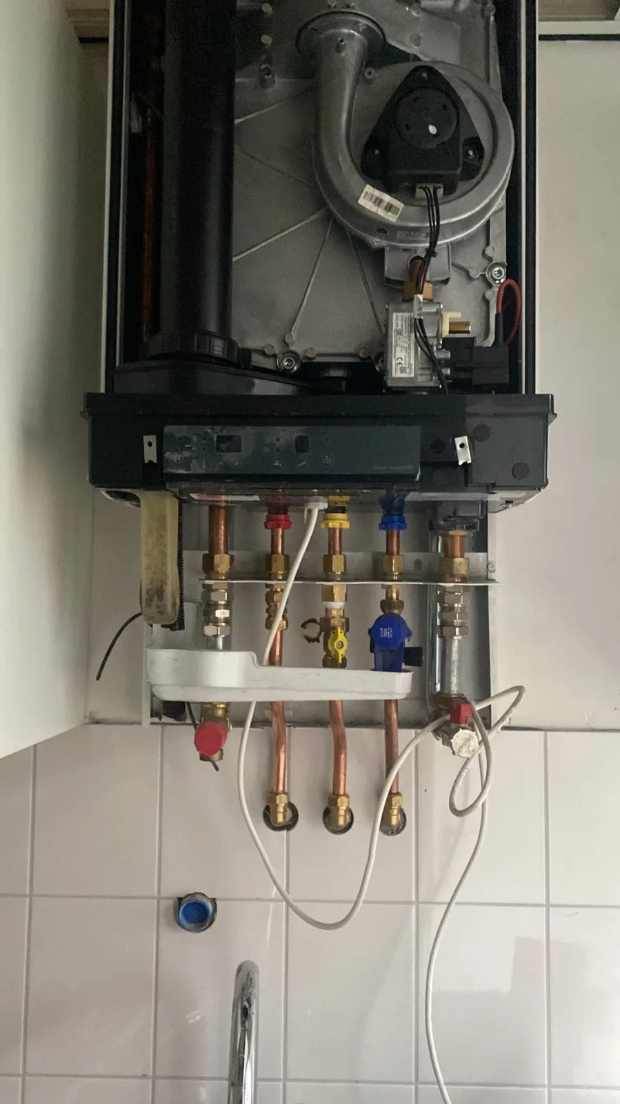 Onderkant van een cv-ketel met gas- en wateraansluitingen