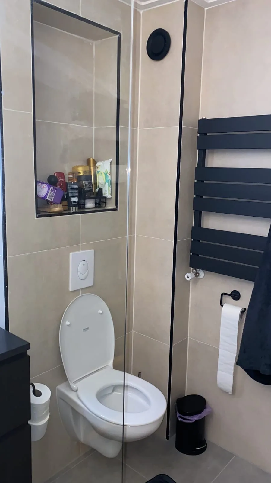 Hangtoilet naast een zwarte designradiator in de badkamer
