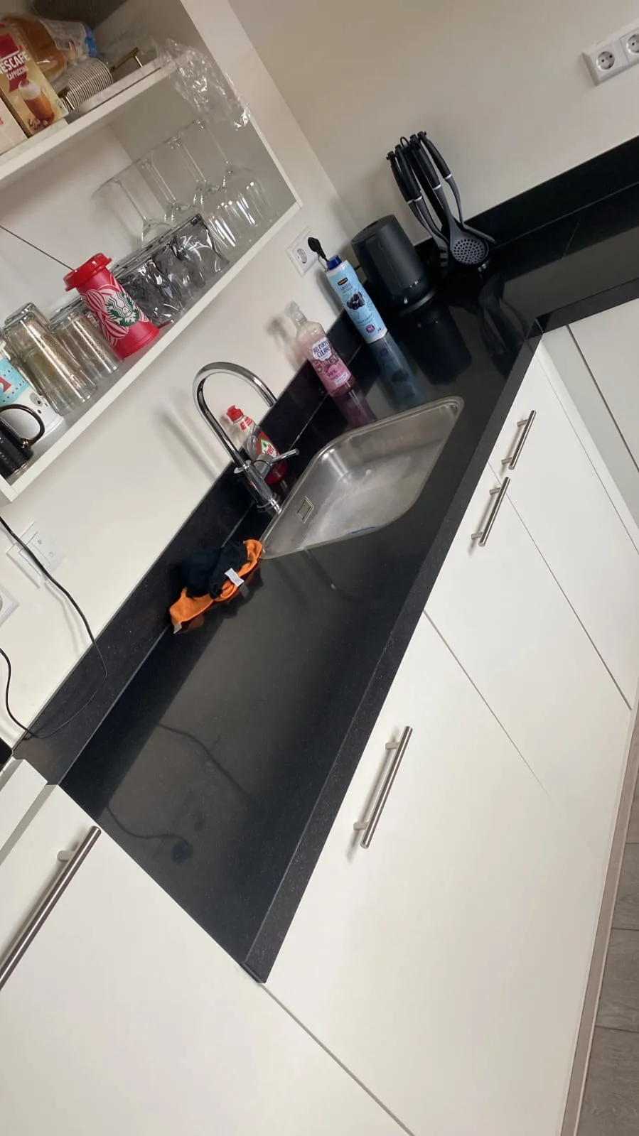 Keuken met zwart werkblad en rvs spoelbak tijdens een reparatie