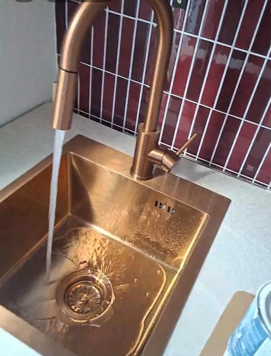 Koperen spoelbak met koperen keukenkraan, water loopt