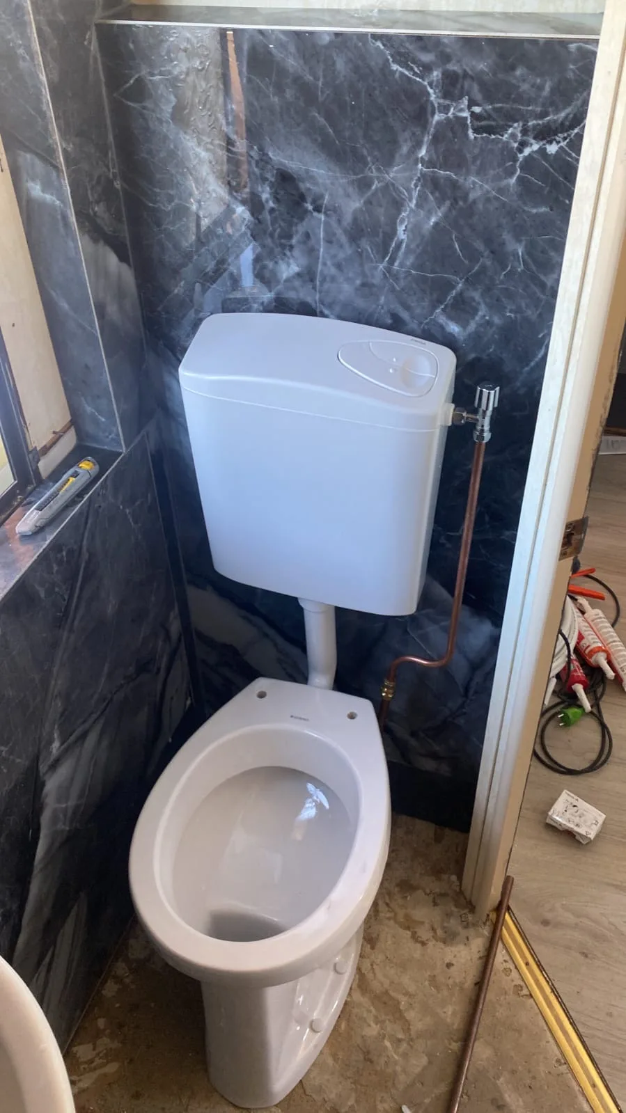 Staand toilet met opbouwreservoir en nieuwe koperen wateraansluiting